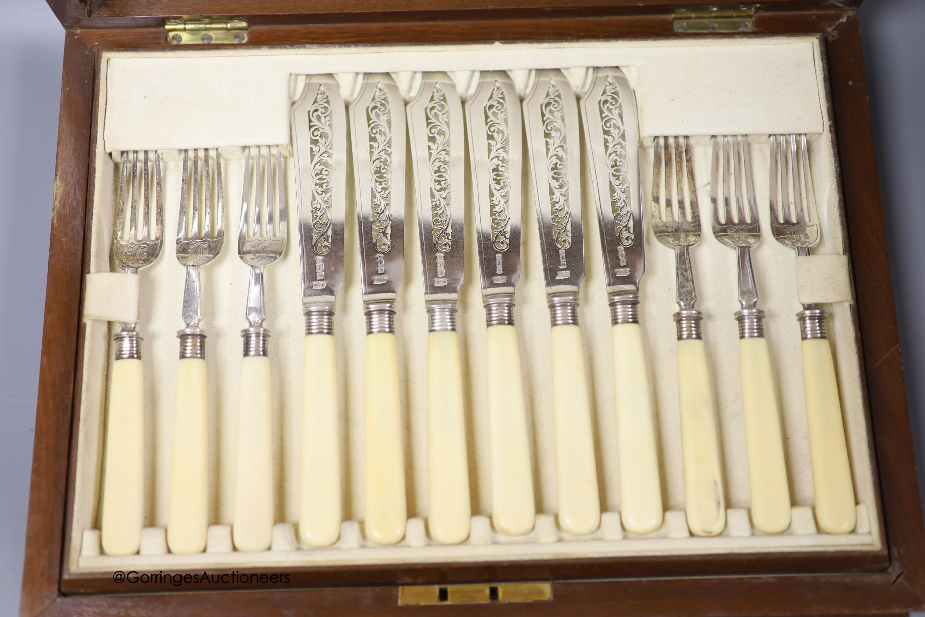 An Edwardian cased set of twelve pairs of ivory handled silver fish eaters, by Mappin & Webb, Sheffield, 1901/2, in walnut canteen